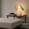 Ahşap sehpa üzerinde konumlandırılmış dekoratif kumaş masa lambası kullanımı